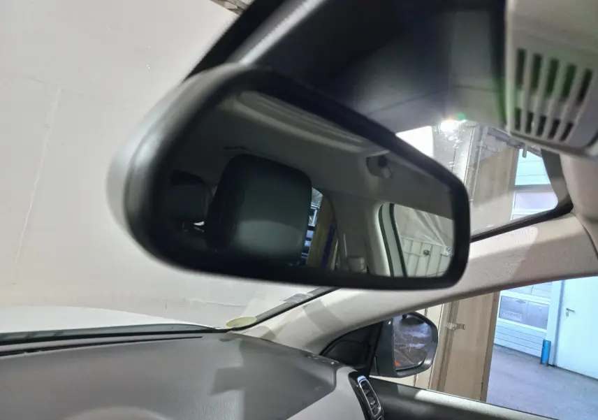 Vue intérieure du rétroviseur central du Citroën C5 Aircross blanc, montrant l'appui-tête arrière et le tableau de bord noir.