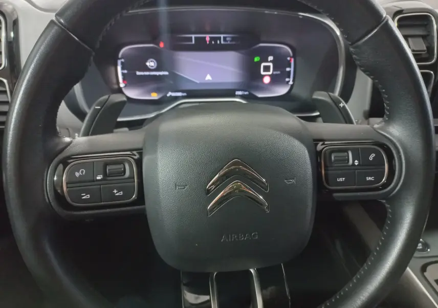 Gros plan sur le volant cuir noir de la Citroën C5 Aircross 2020 avec commandes intégrées et tableau de bord numérique.