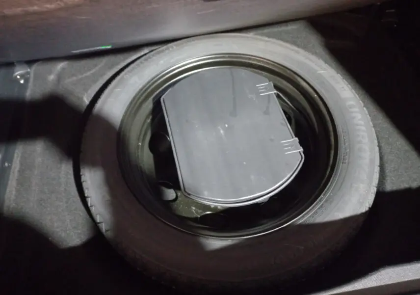 Gros plan sur la roue de secours noire dans le coffre du Citroën C5 Aircross blanc de 2020.