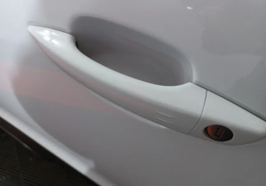 Poignée de porte blanche en gros plan sur le côté gauche d'une Citroën C5 Aircross 2020 finition Feel.