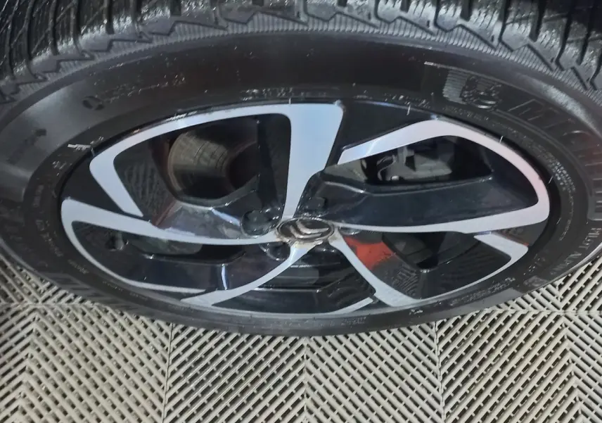 Gros plan sur la jante noire et argentée du Citroën C5 Aircross blanc, montrant le logo central et le pneu Michelin.