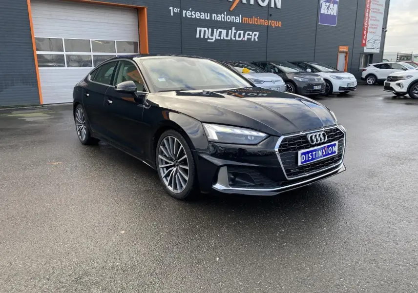 Audi A5 Sportback noir mythic métallisé vue 3/4 avant droit avec jantes multibranches grises contrastées.