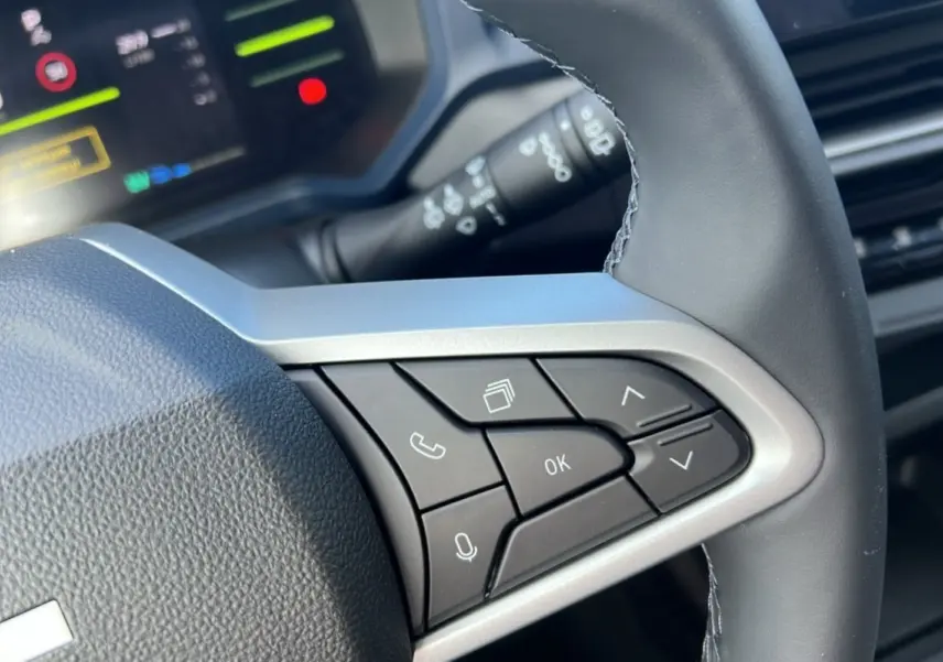 Gros plan sur les commandes multifonctions du volant cuir côté droit du Dacia Bigster Hybrid 155 Expression Plus.