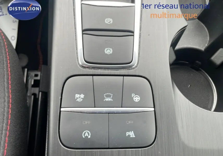 Gros plan sur la console centrale du Ford Kuga 2024, boutons de contrôle d’aide à la conduite et frein électronique.