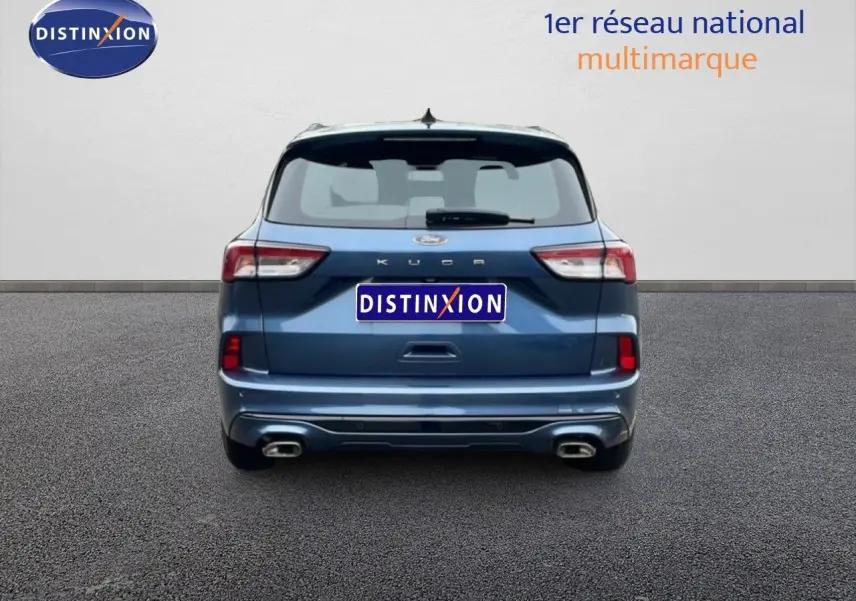 Vue arrière d'un Ford Kuga bleu vapor metal 2024 avec double sortie d'échappement et logo distinctif visible.
