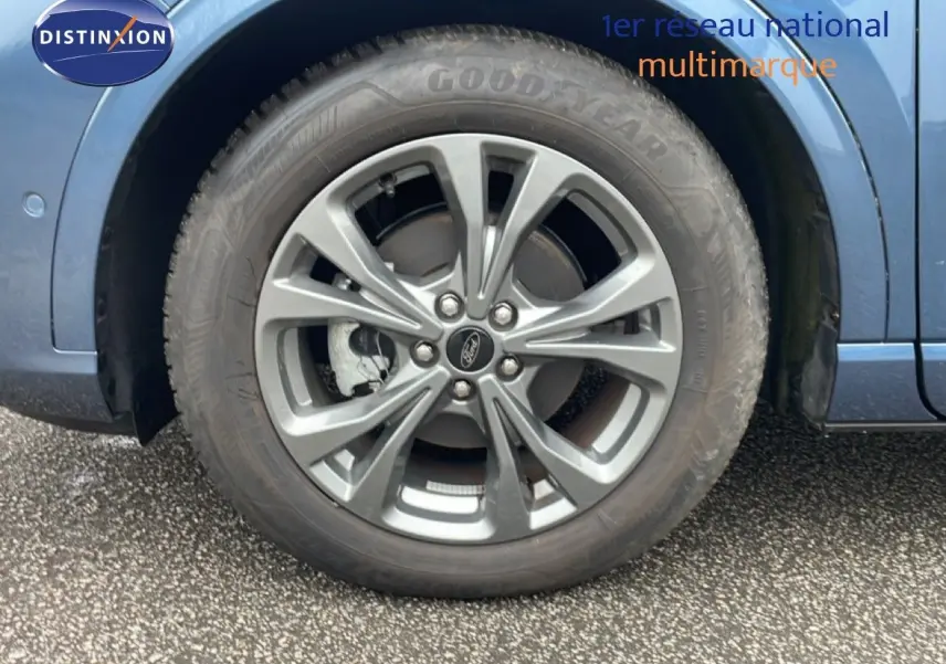 Gros plan sur la roue avant droite du Ford Kuga bleu vapor metal, mettant en valeur la jante alliage et le pneu Goodyear.