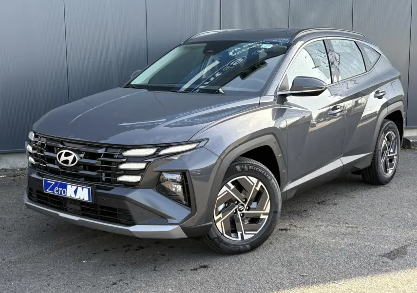 Vue 3/4 avant droite du Hyundai Tucson 2025 gris Ecotronic avec jantes alliage et calandre distinctive.