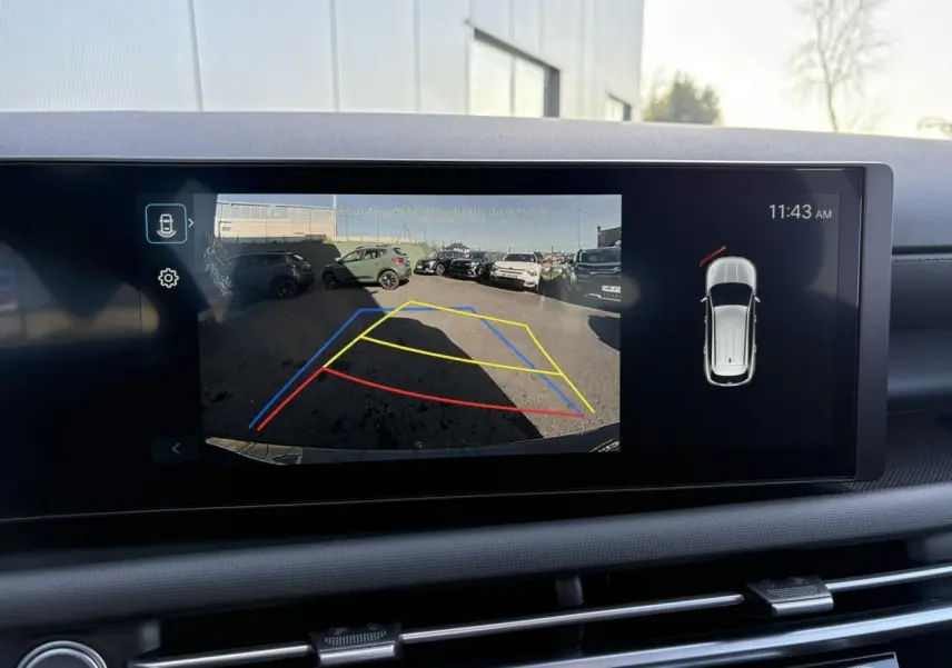 Vue intérieure du tableau de bord du Hyundai Tucson 2025 avec écran affichant la caméra de recul et l’aide au stationnement active.