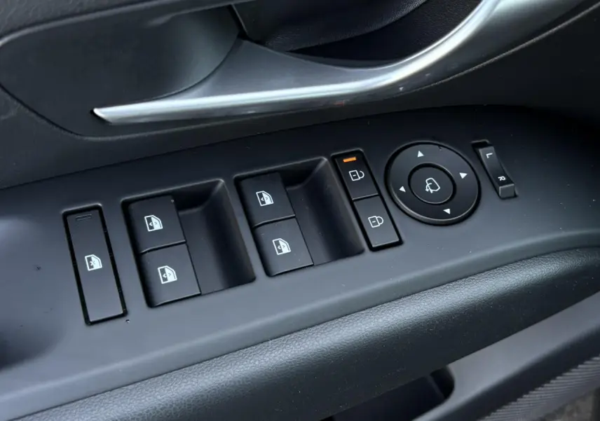 Gros plan sur les commandes de vitres et rétroviseurs côté conducteur du Hyundai Tucson 2025 en Ecotronic Gray.