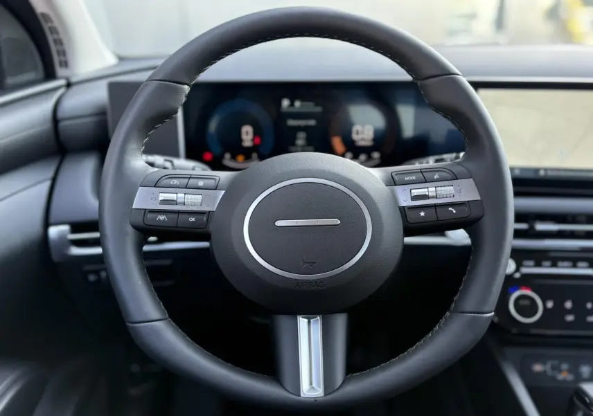 Volant cuir noir avec commandes intégrées, tableau de bord numérique et écran tactile du Hyundai Tucson 2025.
