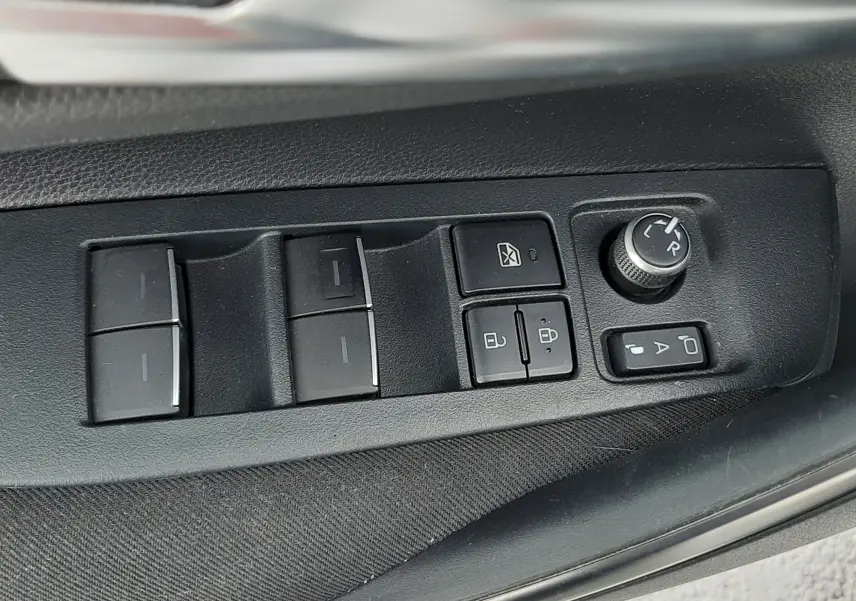 Panneau de commande des vitres et rétroviseurs côté conducteur de la Toyota Corolla blanche 2022 en gros plan.