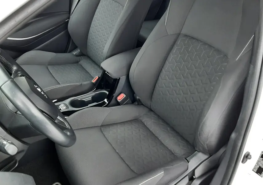 Vue intérieure côté gauche de la Toyota Corolla 122 CH Dynamic 2022, sièges tissu gris avec surpiqûres blanches.