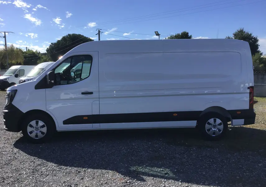 Vue de profil côté gauche d’un utilitaire Renault Master blanc L3H2 avec bandeau noir et jantes argentées.
