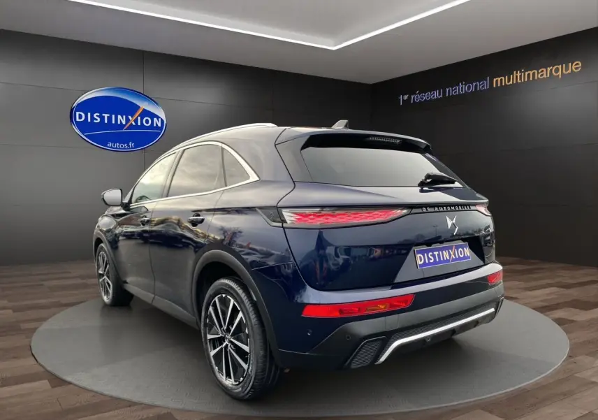 Vue 3/4 arrière du SUV DS7 Bleu Éclipse, avec feux arrière allongés et jantes alliage bicolores visibles.