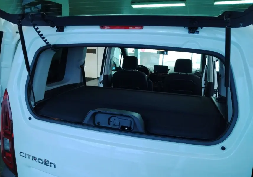 Vue arrière ouverte du Citroën Berlingo blanc 2025, montrant l'intérieur et la cloison de séparation amovible.