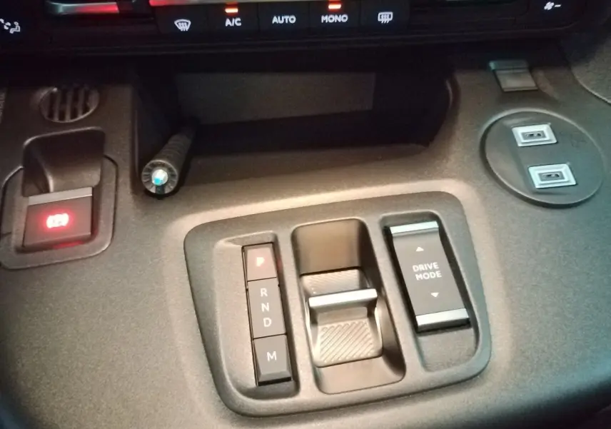 Vue rapprochée de la console centrale du Citroën Berlingo blanc 2025, avec commande de boîte auto et bouton Drive Mode.