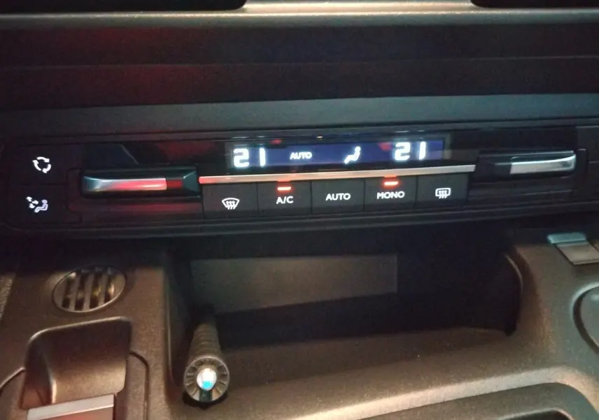 Détail du tableau de bord du Citroën Berlingo 2025 montrant la commande de climatisation digitale avec affichage des températures à 21°C.