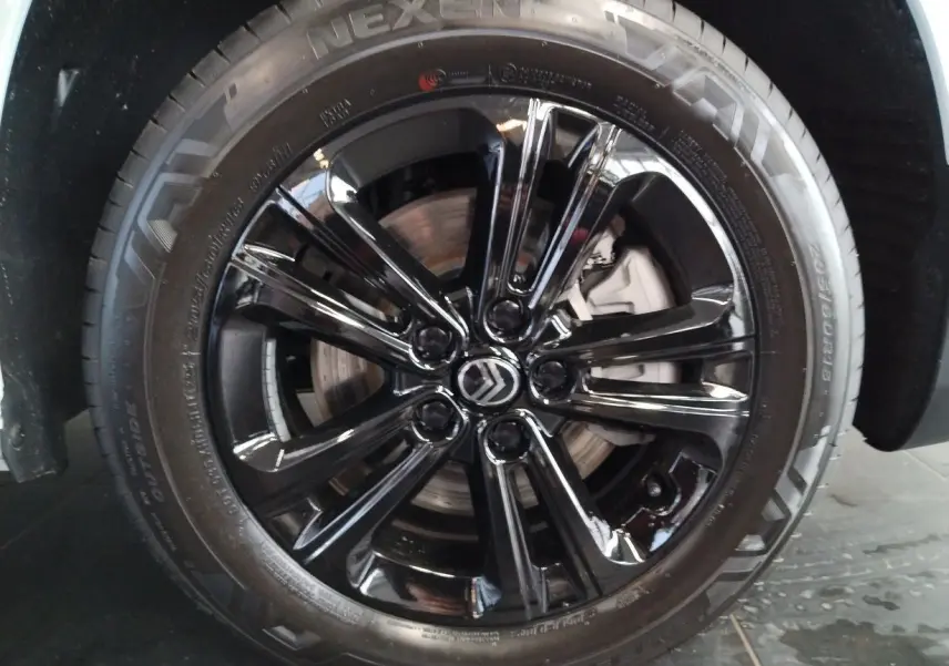 Gros plan sur la jante alu noir Starlit avec logo Citroën au centre du CITROEN BERLINGO blanc 2025.