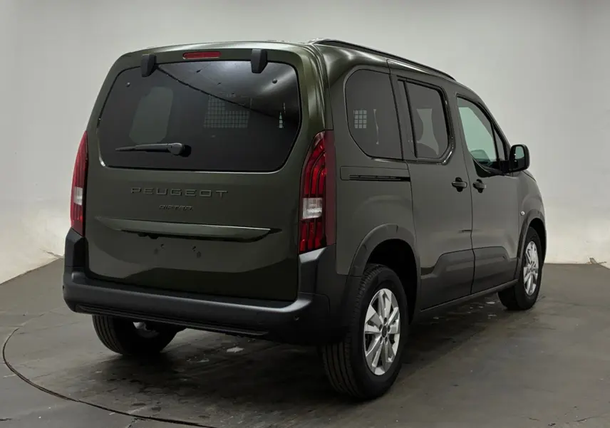 Vue 3/4 arrière droite d’un Peugeot Rifter 2026 vert Sirkka avec vitres arrière surteintées et jantes alliage.