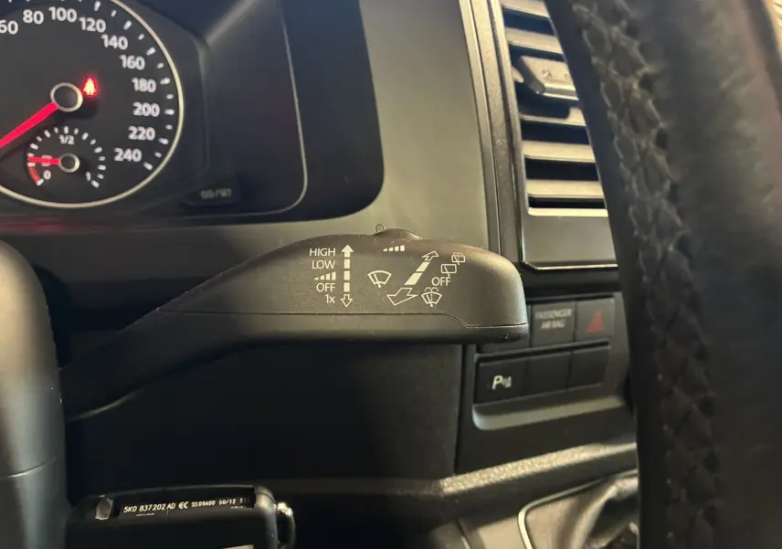Gros plan sur la manette d'essuie-glace côté droit du tableau de bord d'un Volkswagen Multivan noir T6 2015.