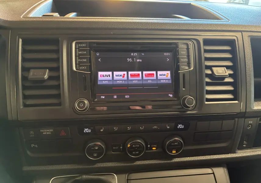 Vue rapprochée du tableau de bord noir du Volkswagen Multivan T6 avec écran tactile et commandes de climatisation.