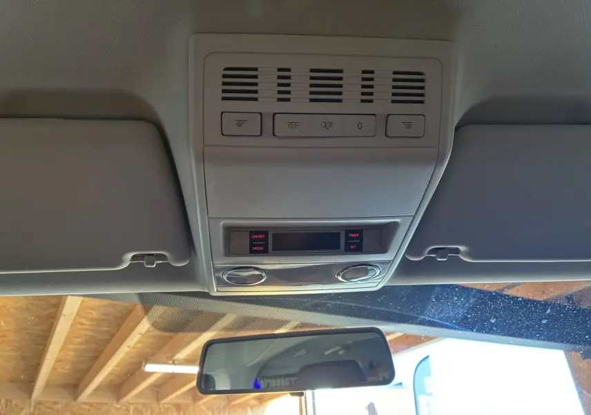 Vue intérieure du plafond avant du Volkswagen Multivan T6 noir, avec commandes d'éclairage et rétroviseur central visible.