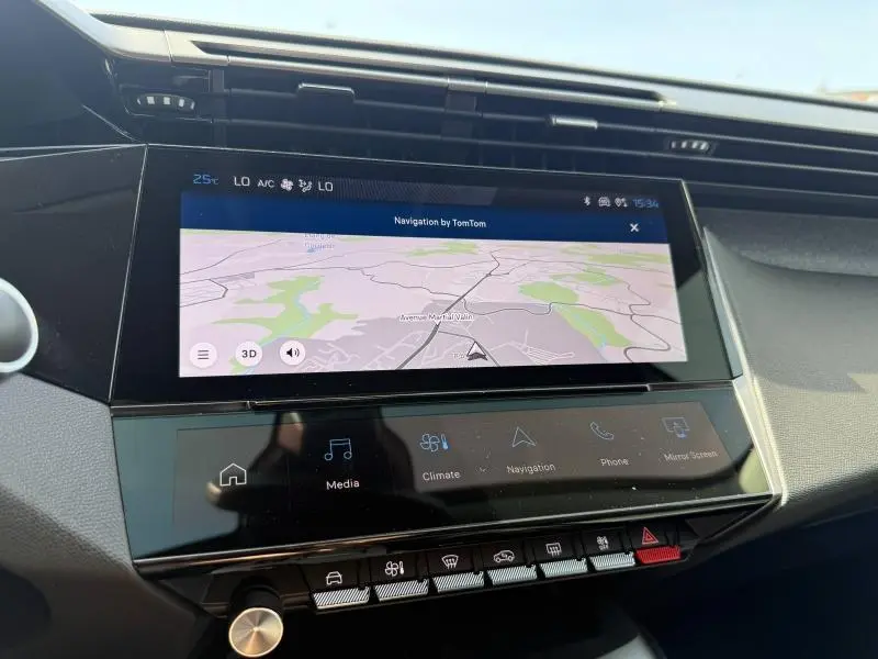 Vue rapprochée de l’écran tactile central du tableau de bord de la Peugeot 308 1.2 Hybrid blanche, affichant la navigation.