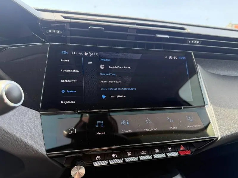 Vue rapprochée de l’écran tactile central du tableau de bord de la Peugeot 308 hybride blanche, affichant les réglages système.