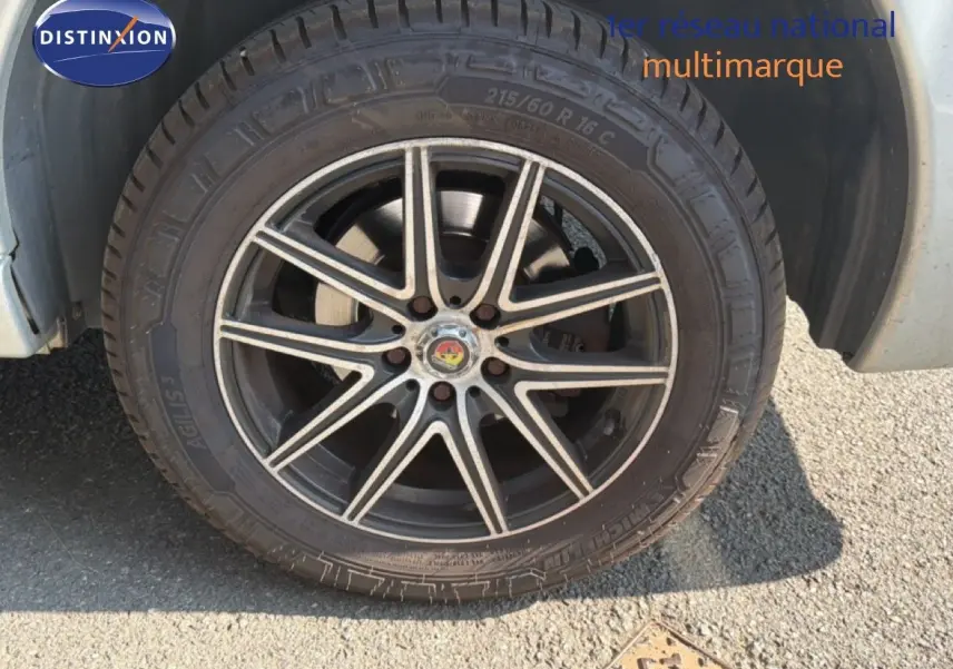 Gros plan sur la roue avant gauche du FIAT Scudo Fourgon gris métal, avec jante alliage noire à motifs argentés.