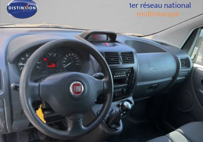 Vue intérieure côté conducteur du tableau de bord et volant noir du Fiat Scudo Fourgon gris métal de 2016.