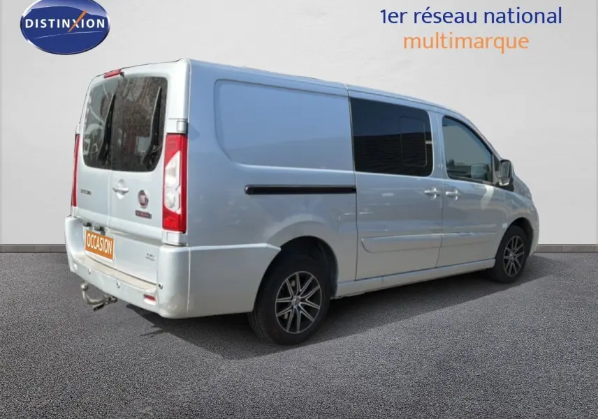 Vue 3/4 arrière droite d'un FIAT Scudo Fourgon gris métal avec vitres teintées et jantes alliage noires.