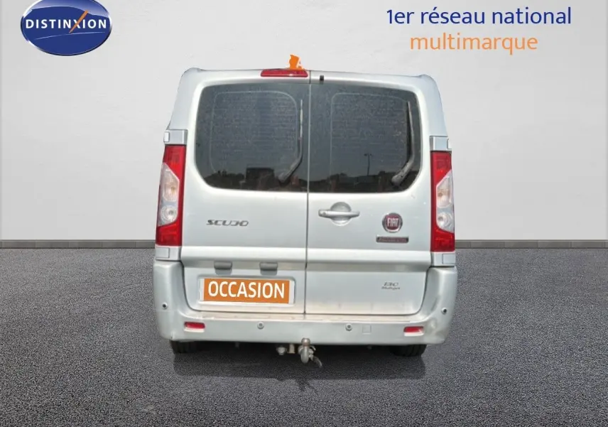 Vue arrière d'un FIAT Scudo Fourgon gris métal de 2016 avec hayon double portes et attelage visible.