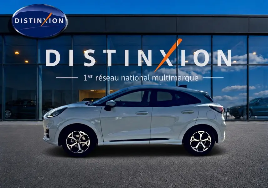 Ford Puma gris cactus vue de profil droit devant une vitrine avec logo Distinxion, jantes alu et vitres surteintées.