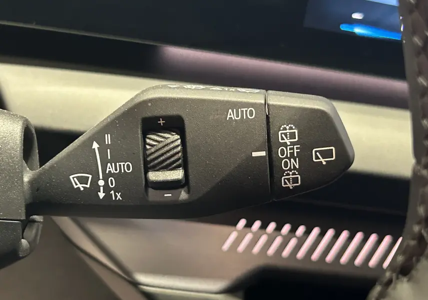 Gros plan sur la commande d’essuie-glace automatique dans l’habitacle de la BMW Série 1 gris Skyscrap 2024.