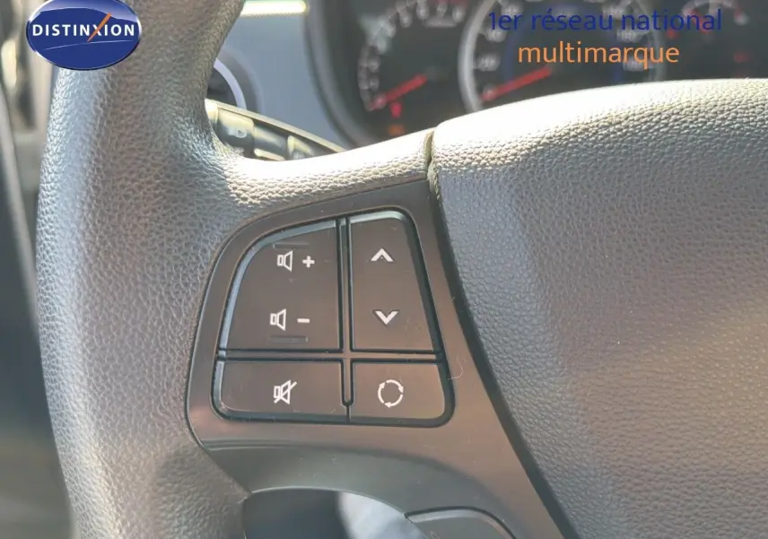 Gros plan sur les commandes audio au volant d'une Hyundai i10 blanche de 2018, version 1.0 66 Intuitive.