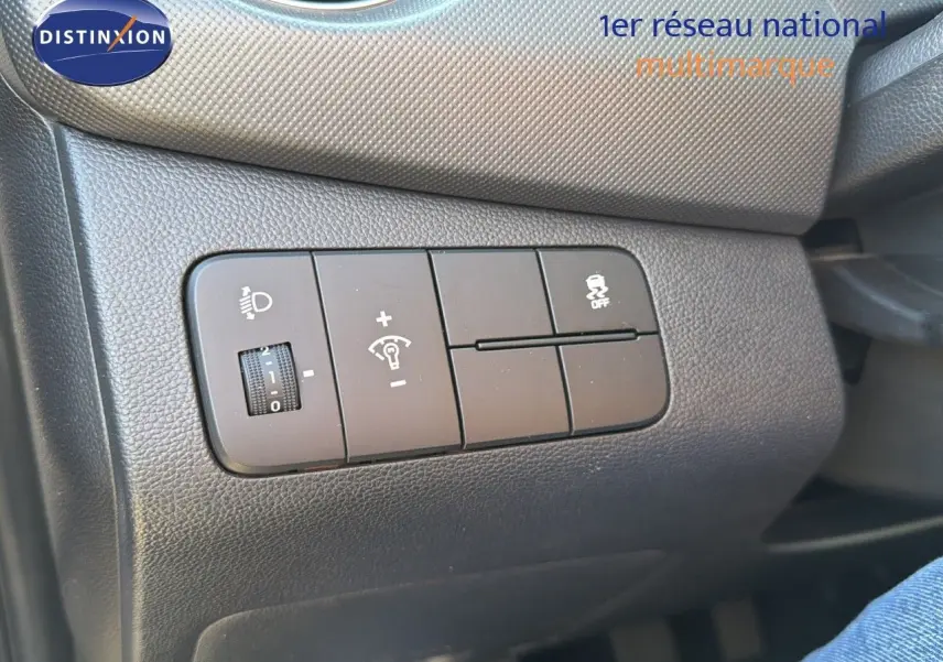 Gros plan sur les commandes de réglage d'éclairage et de stabilité dans l'habitacle d'une Hyundai i10 blanche 2018.