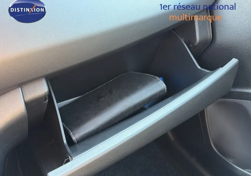 Gant de rangement ouvert côté passager d'une Hyundai i10 blanche 2018 avec manuel dans la boîte à gants.