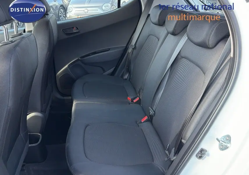 Vue intérieure côté droit sur les sièges arrière noirs d'une Hyundai i10 blanche 2018, porte ouverte.