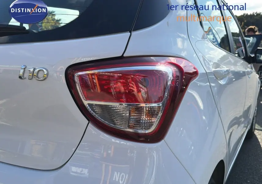 Feu arrière droit et logo i10 sur une Hyundai i10 blanche vue de l'arrière côté droit.