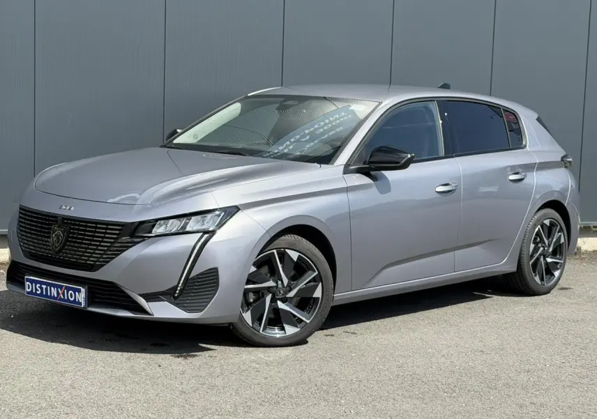 Peugeot 308 gris Artense vue 3/4 avant droit, avec jantes alliage 17'' et calandre noire brillante.