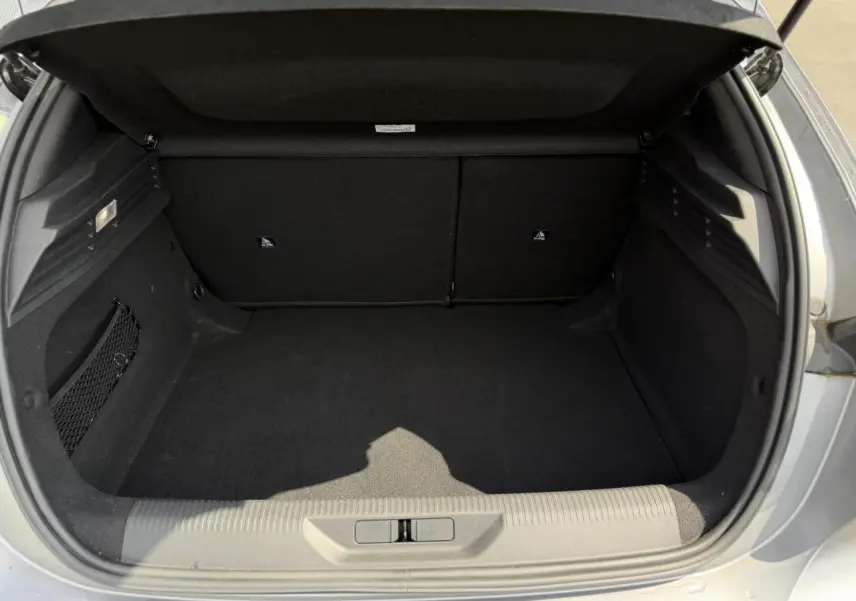 Coffre ouvert vu de l'arrière d'une Peugeot 308 gris Artense, montrant un espace de rangement vide et propre.