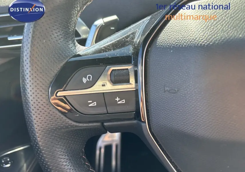 Gros plan sur les commandes au volant en cuir perforé du Peugeot 5008 blanc nacré, version BlueHDi 130 EAT8 GT 2023.