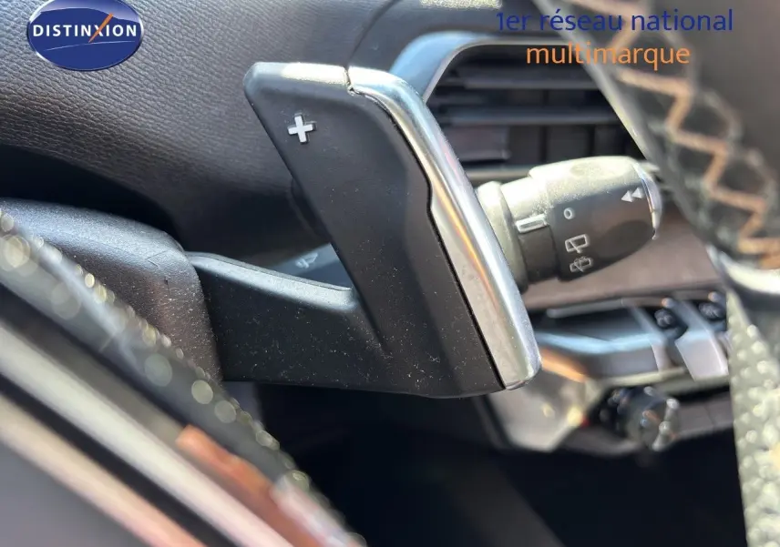 Gros plan sur la palette de changement de vitesse droite en aluminium et plastique noir dans l’habitacle du Peugeot 5008 blanc nacré.