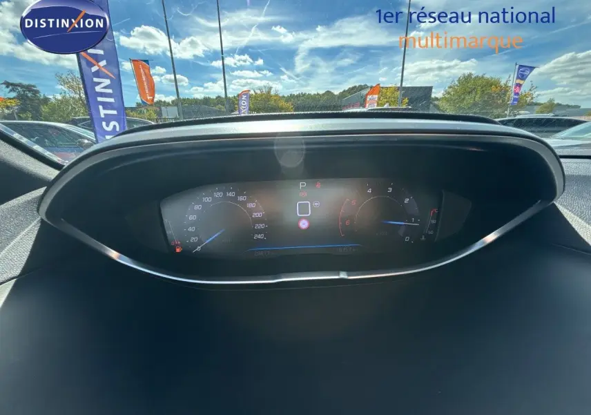 Vue rapprochée du tableau de bord numérique du Peugeot 5008 blanc nacré, affichant vitesse et compte-tours.