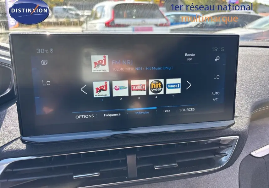 Écran tactile central du Peugeot 5008 GT 2023 montrant les stations radio, avec tableau de bord et aérateurs visibles.