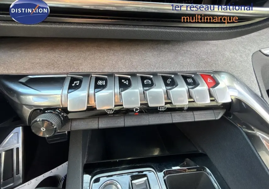 Gros plan sur la rangée de boutons métalliques du tableau de bord du Peugeot 5008 blanc nacré, version GT 2023.