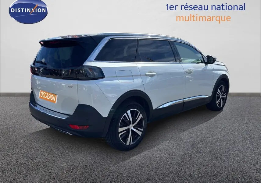 Peugeot 5008 BlueHDi 130 GT blanc nacré vu en 3/4 arrière droit, avec vitres teintées et jantes alliage bicolores.