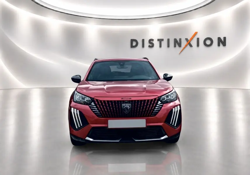 Vue frontale d’un Peugeot 2008 rouge elixir avec calandre verticale et feux LED distinctifs, sur fond blanc lumineux.