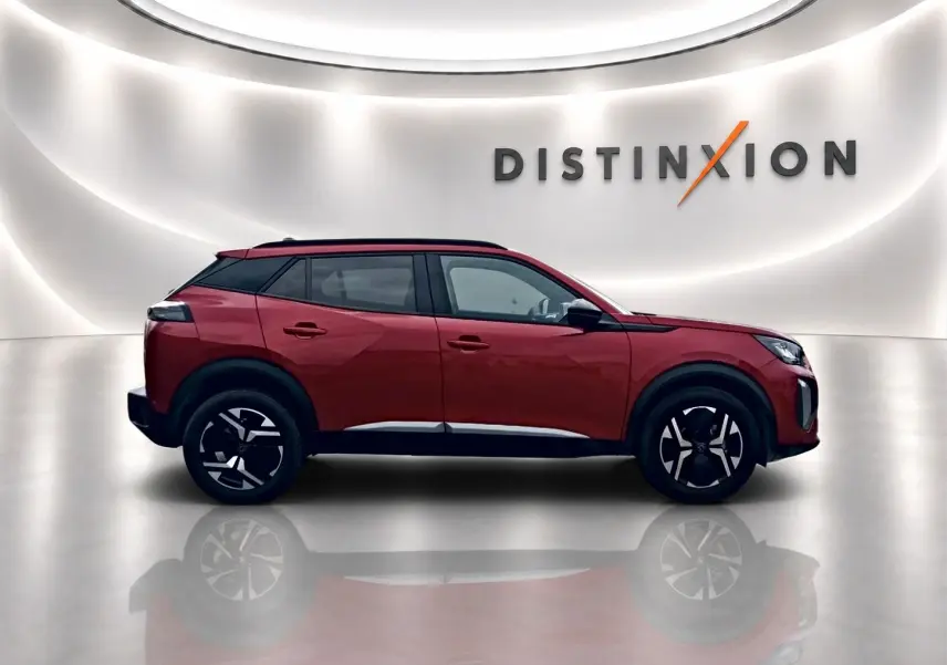 Profil droit du Peugeot 2008 1.2 100 Allure rouge elixir avec jantes alu et toit noir dans un studio lumineux.