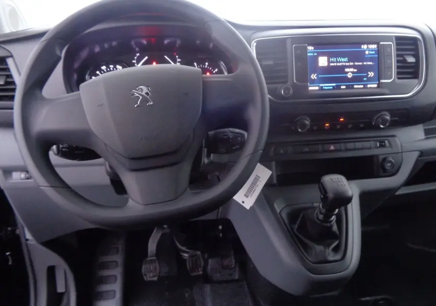 Vue intérieure du tableau de bord et volant Peugeot Expert Fourgon noir, avec levier de vitesse manuel et écran tactile.